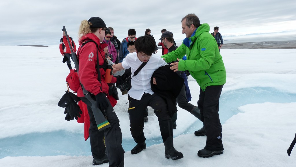 徒步穿越冰川时，在探险队员和同船外国友人的帮助下跨越冰河（刘丽摄）