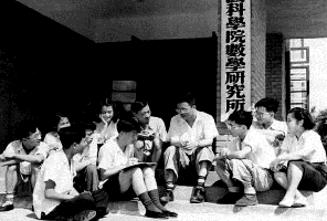 1953年夏天，华罗庚和青年学生们坐在数学所的大门口.png